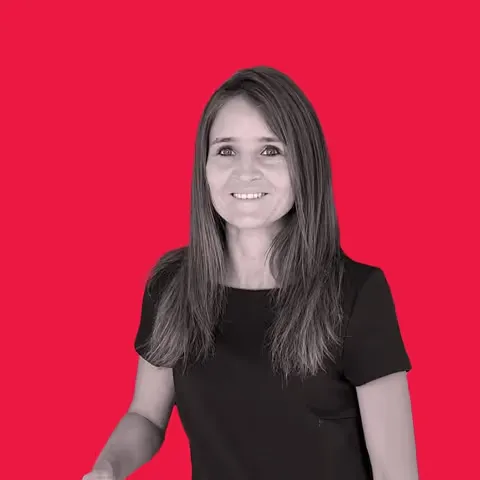 Smiling woman with long brown hair wearing a black shirt against a red background.